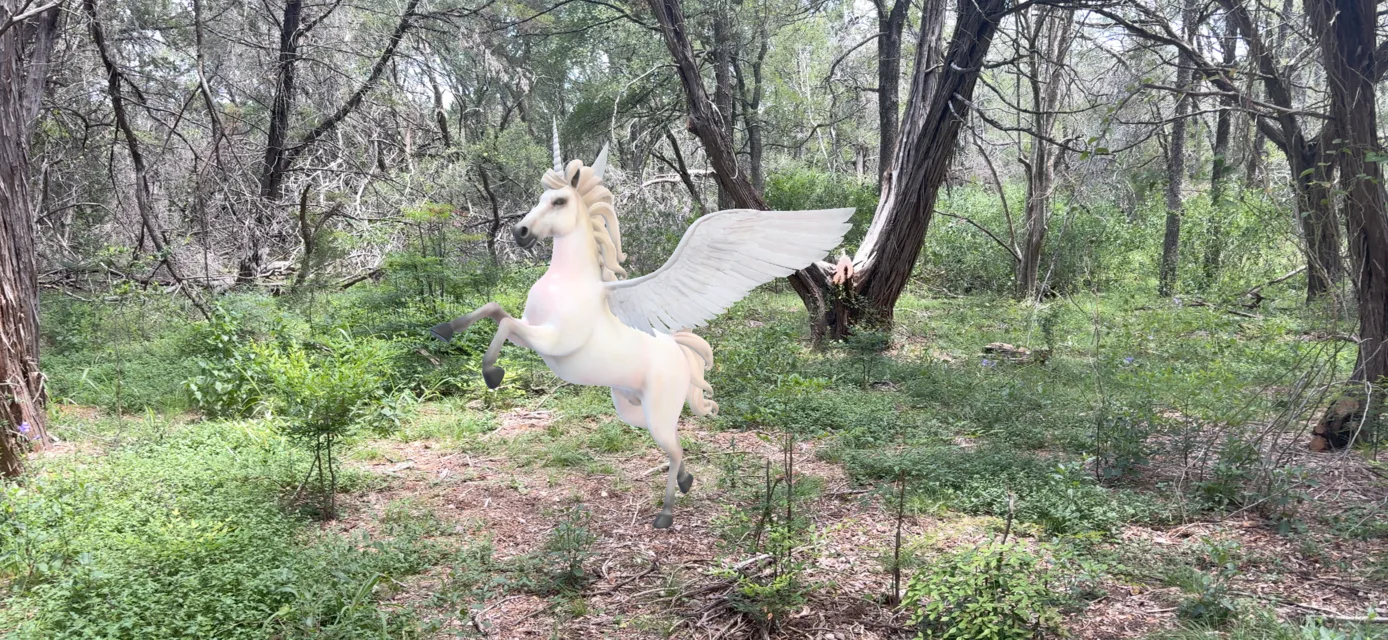A winged unicorn standing among the trees in augmented reality